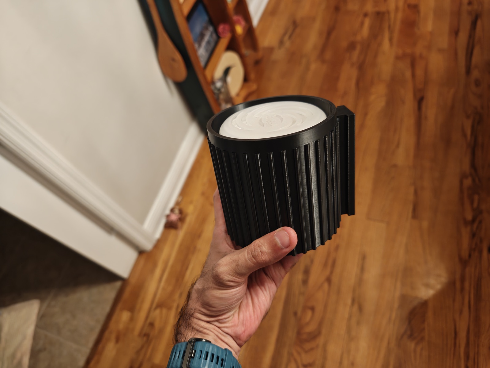 Fluted black sleeve holding a deodorizer puck