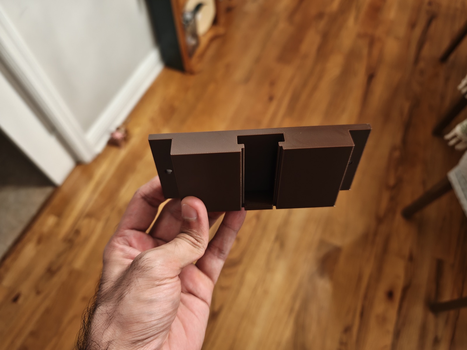 Brown wall bracket with screw holes and a sliding rail